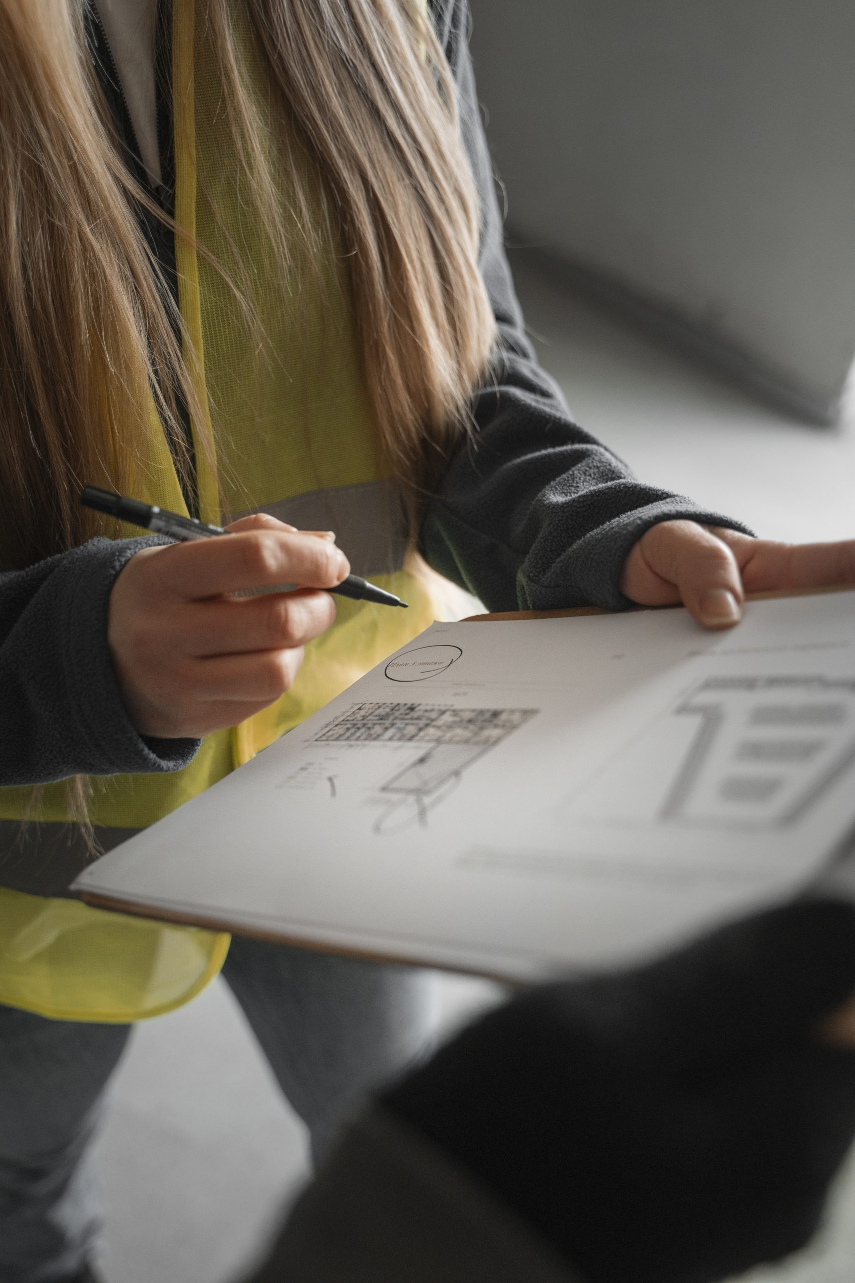 Assistante administrative BTP travaillant sur des documents de chantier dans les Hautes-Alpes